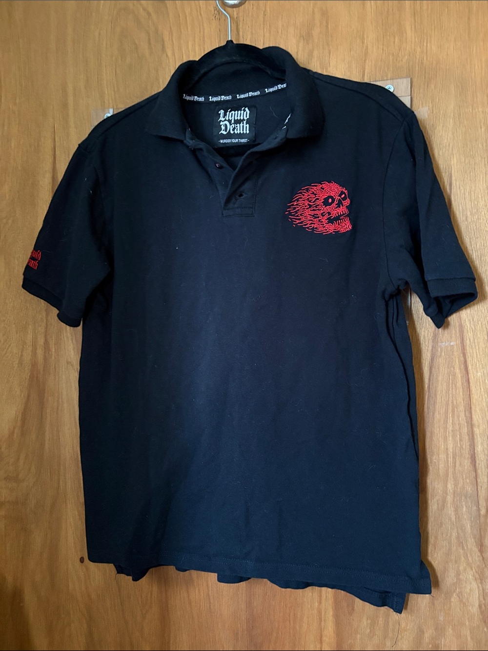 Liquid Death Men’s Black Polo Shirt with Red Flaming Skull Graphic